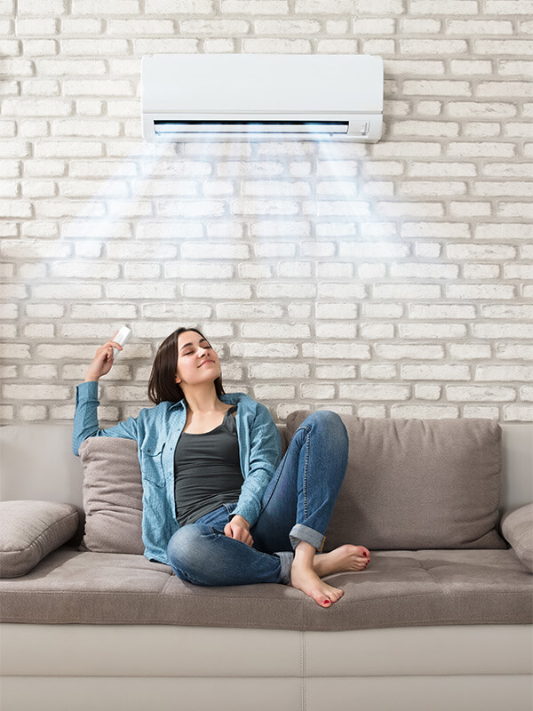 woman on couch adjusting ac